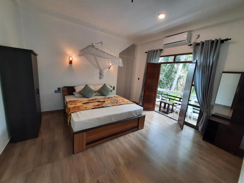 a bedroom with a bed and a large window at Villa Freiheit Himmel in Bentota