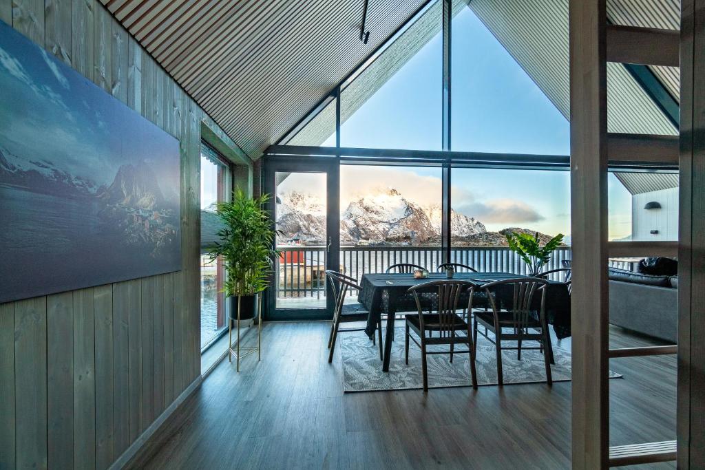 a dining room with a table and a view of a mountain at Rorbuleilighet 1J Henningsvær in Henningsvær
