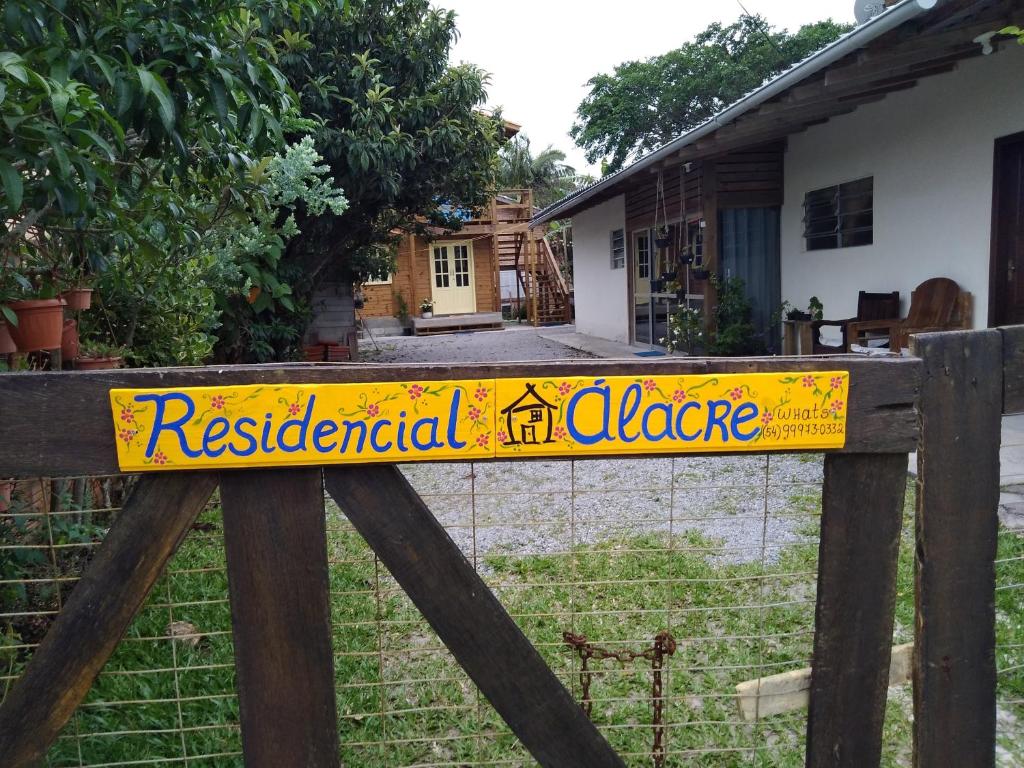 a yellow sign on a fence in front of a house at Residencial Álacre casa e cabana aluguel Ferrugem SC in Garopaba