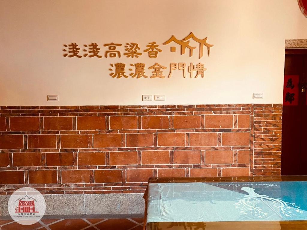 Una pared de ladrillo con escritura asiática. en 金門山前李家民宿, en Jincheng
