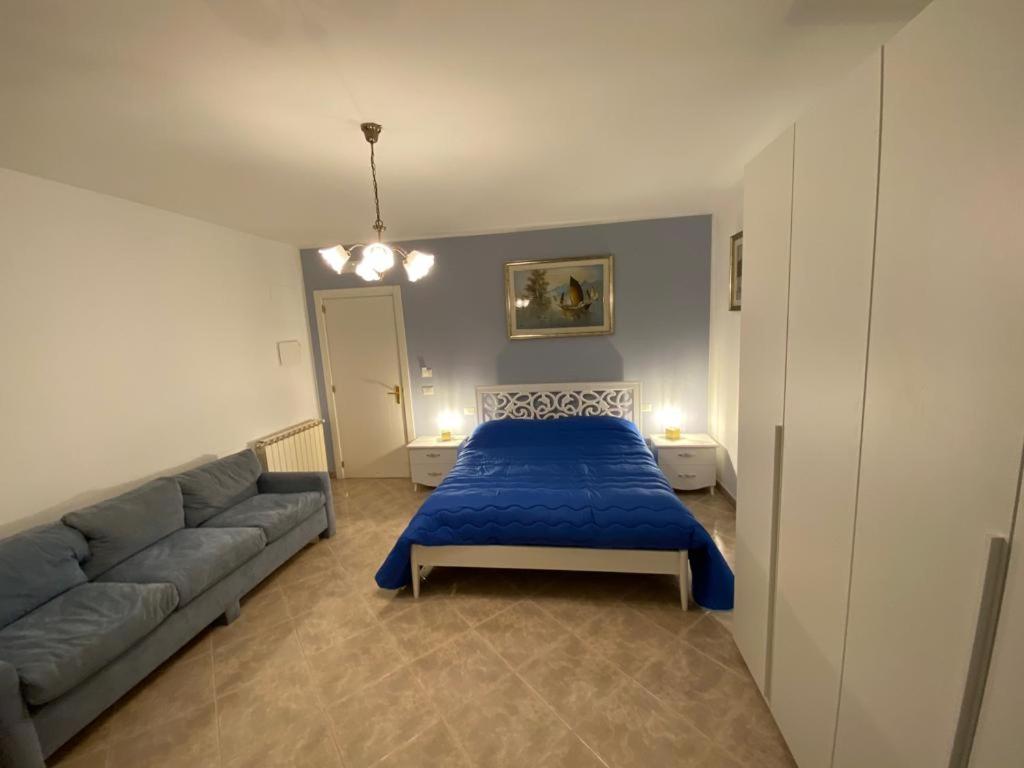 1 dormitorio con 1 cama azul y 1 sofá en Residenze BepiLù en Bari