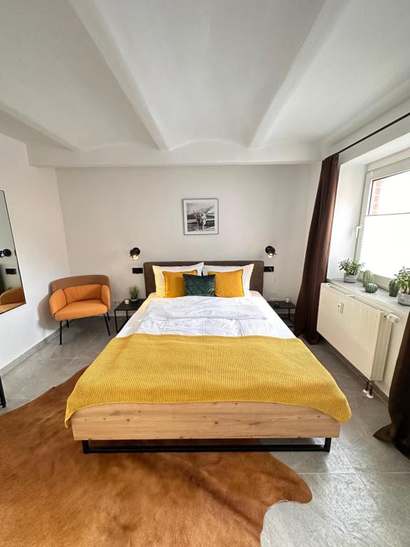 1 dormitorio con 1 cama grande con manta amarilla en Appartement Auhagen - Küche, Badewanne, Regendusche, Netflix, en Auhagen