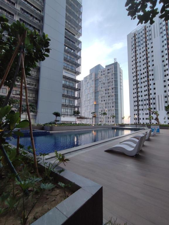 a swimming pool in a city with tall buildings at DeAr UC Apartment in Surabaya