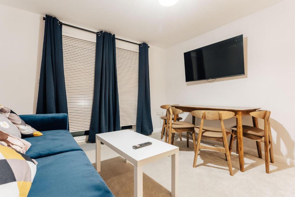 salon z niebieską kanapą i stołem w obiekcie Stunning 2 bedroom flat in town w Bournemouth