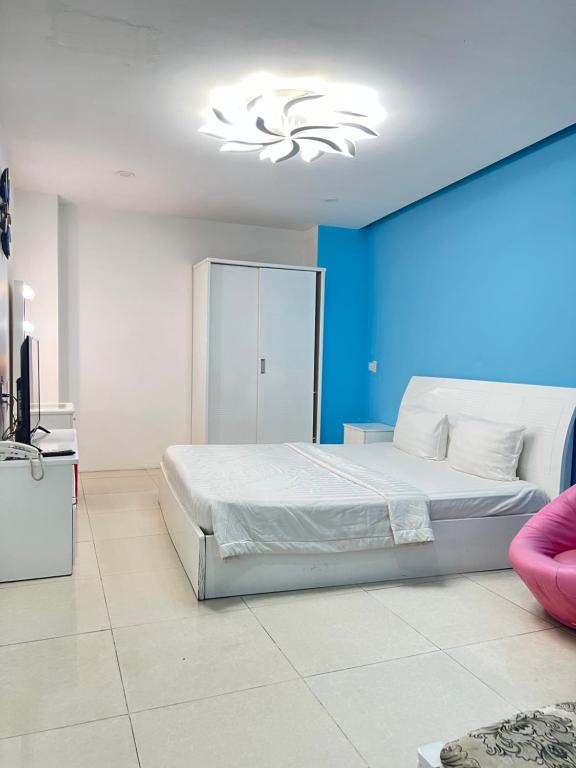 a bedroom with a white bed and a blue wall at Valentine Luxury hotel - 31 Bui Vien Street in Ho Chi Minh City
