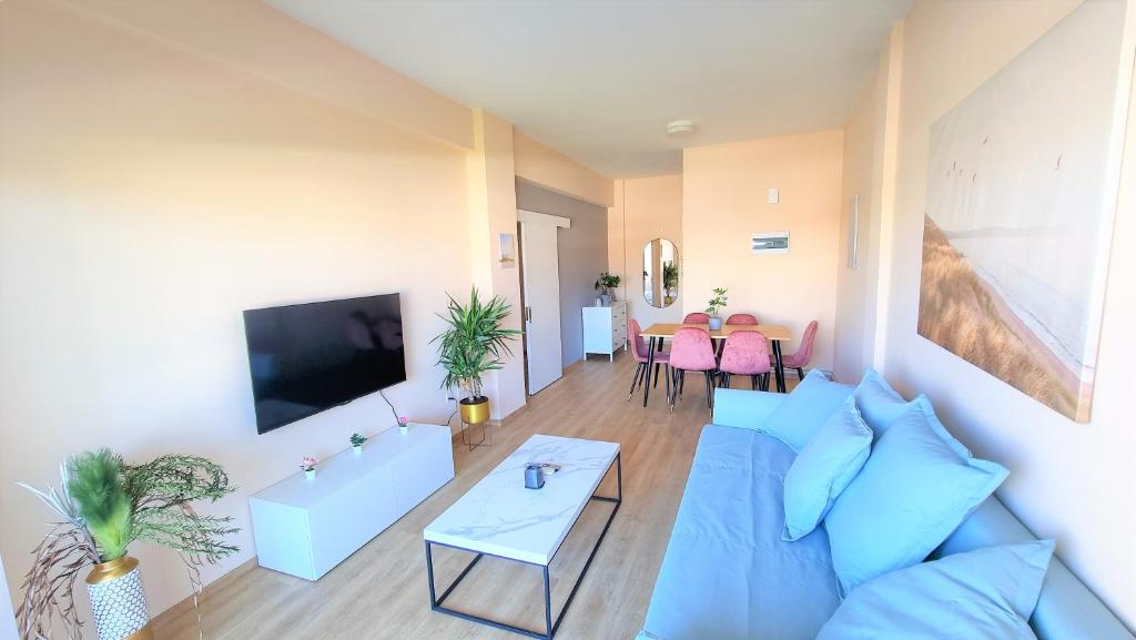 a living room with a blue couch and a tv at The Urban Oasis - Comfort 2br near the City Center, 200Mbit Internet and Smart TV in Larnaca