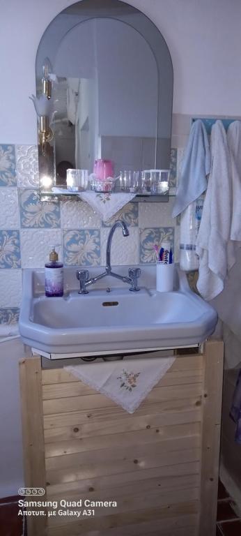 łazienka z umywalką i lustrem w obiekcie Elizas house w mieście Nea Makri