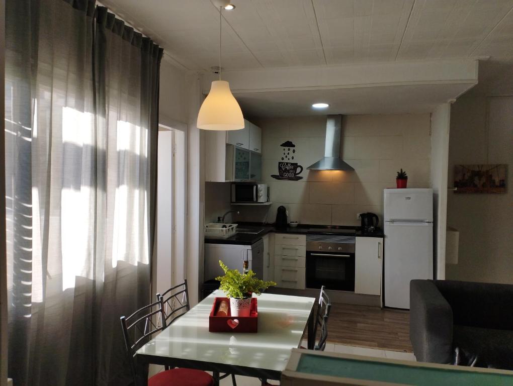 eine Küche mit einem Tisch und eine Küche mit einem Kühlschrank in der Unterkunft Day Ok Beach Apartment in Malgrat de Mar