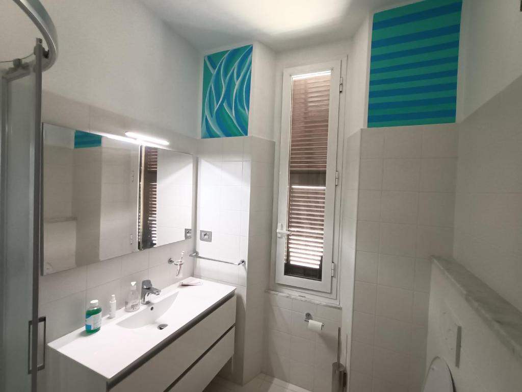 un bagno bianco con lavandino e specchio di City View! Panoramic Apartment overlooking La Spezia a La Spezia