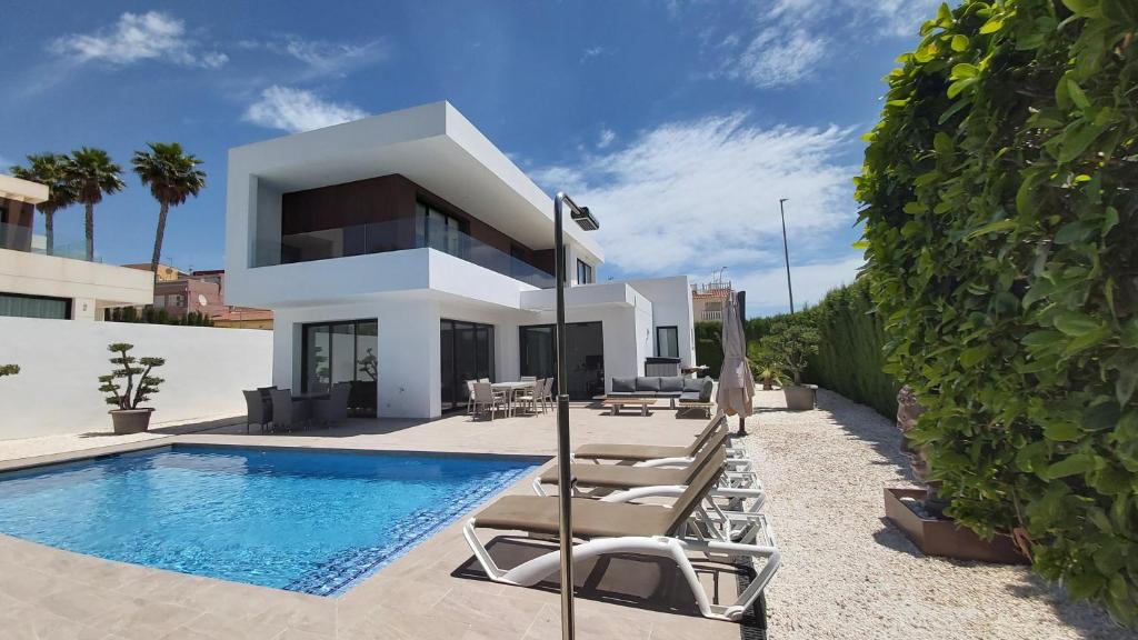 a villa with a swimming pool and lounge chairs at Villa La Marina in La Marina