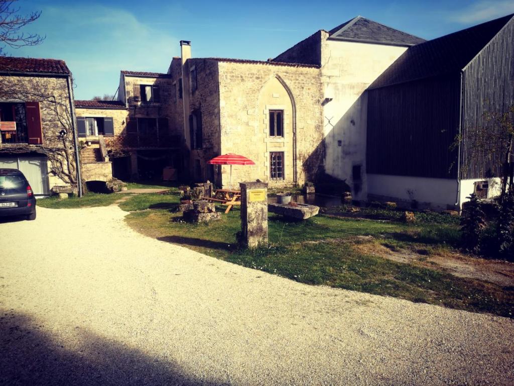 a building with a red umbrella in front of it at Chambres en maison d'hôtes Le Moulin d'Annepont in Annepont