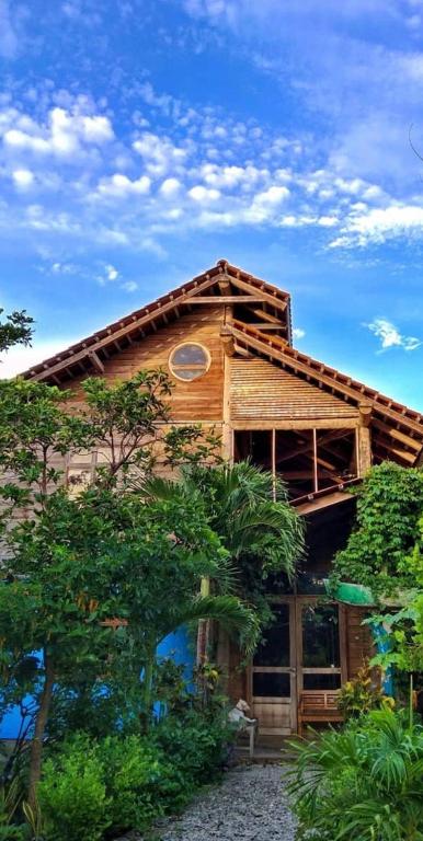 una casa de madera con techo abuhardillado en Oro Beach Houses, en Weetebula