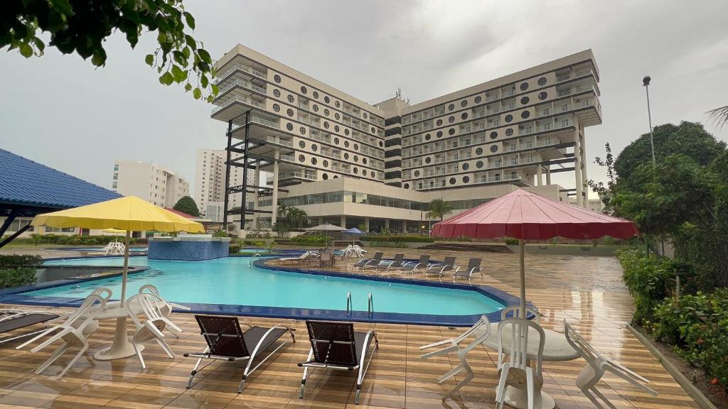 a hotel with a pool and chairs and a building at HOTEL RESORT RIO POTY in São Luís