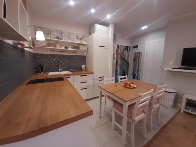 a kitchen with a wooden table and a dining room at Apartament Nad Zatoką Puck in Puck