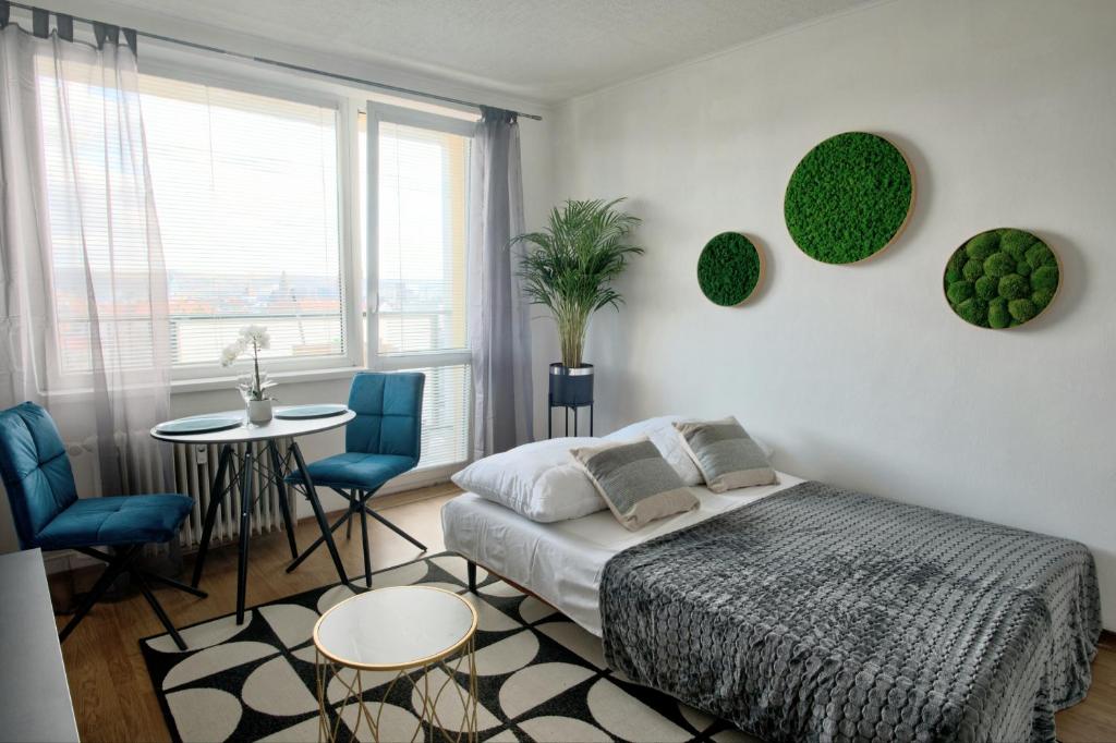 a bedroom with a bed and a table and chairs at Moderny byt, 300 m do centra mesta in Košice