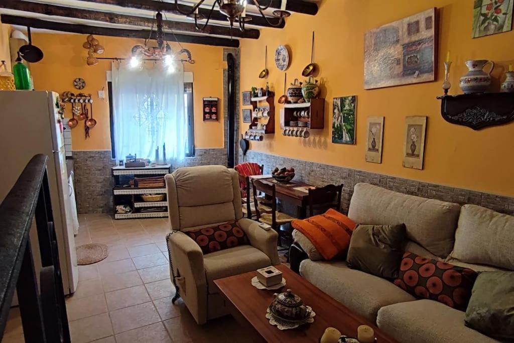 uma sala de estar com um sofá, cadeiras e uma mesa em Casa Elvira 