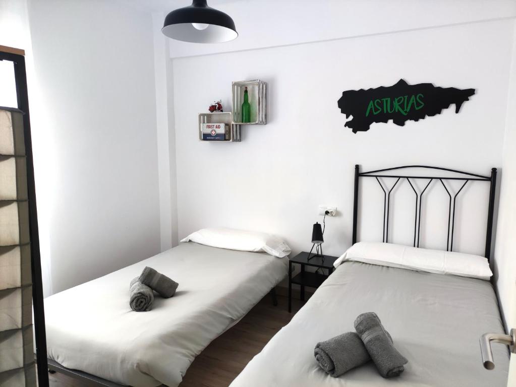 dos camas sentadas una al lado de la otra en una habitación en Apartamento Casa Aurelio, en Gijón