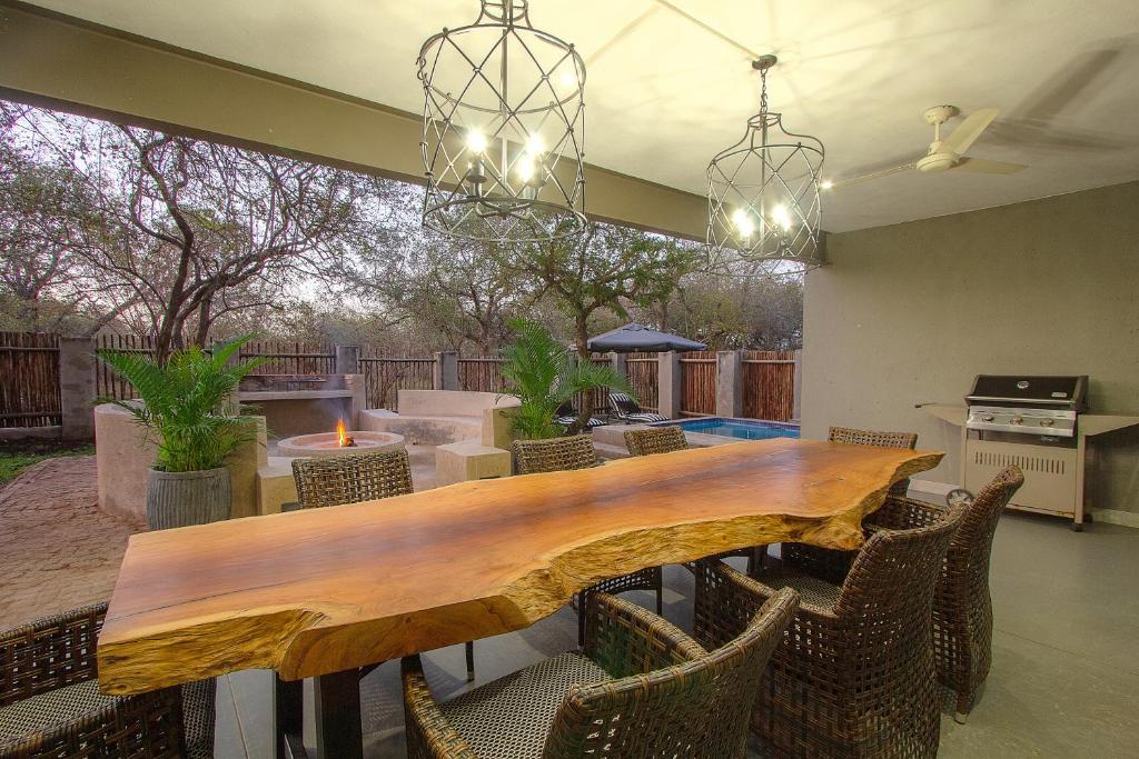 jadalnia z drewnianym stołem i krzesłami w obiekcie 3433 on Klipspringer Marloth Park Kruger w mieście Marloth Park
