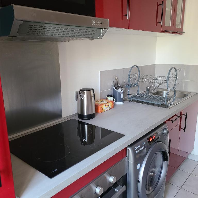 uma cozinha com fogão forno ao lado de uma máquina de lavar roupa em Appartement Brest avec belles prestations em Brest