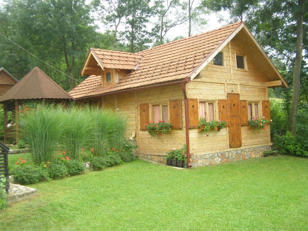 庫察的住宿－Guesthouse Kuzmanovic，一座小木房子,在院子里种花