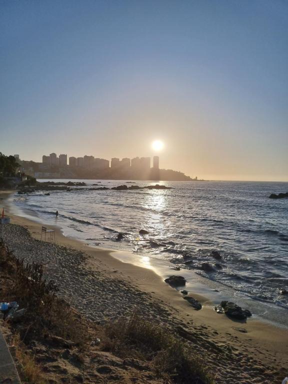 - une plage au soleil se levant au-dessus de l'océan dans l'établissement Hermoso y acogedor departamento a pasos del mar - Ideal Parejas, Teletrabajo, à Concón