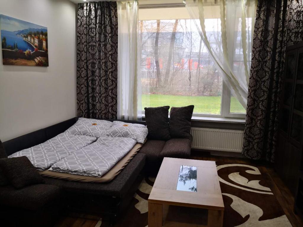 a bedroom with a bed and a couch and a window at Messe Büro in Nürnberg