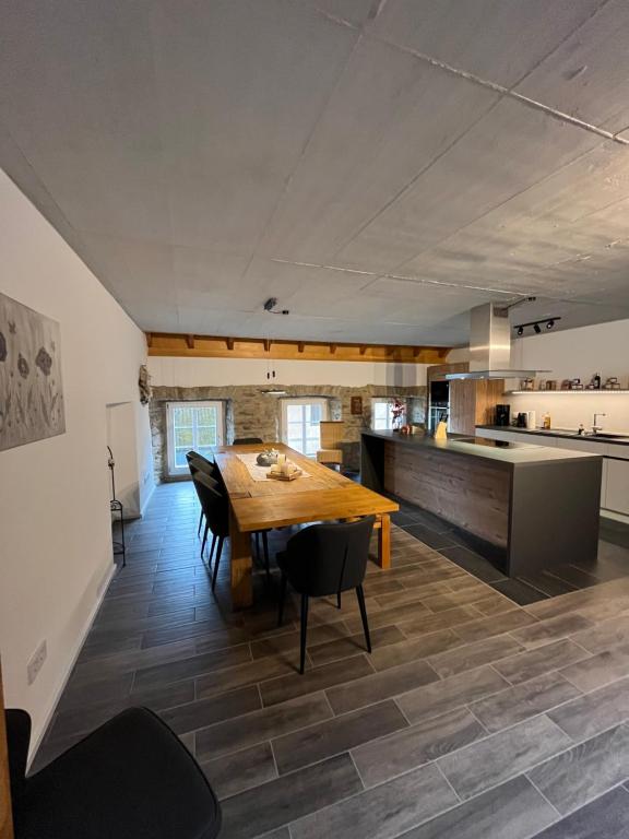 a kitchen and dining room with a wooden table and chairs at Ferienwohnung am Wald-und Wiesenkorb in Kell