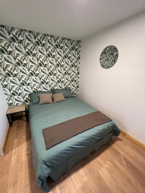 ein Schlafzimmer mit einem Bett und einer Wand in der Unterkunft Les gîtes de la bergerie in Meximieux