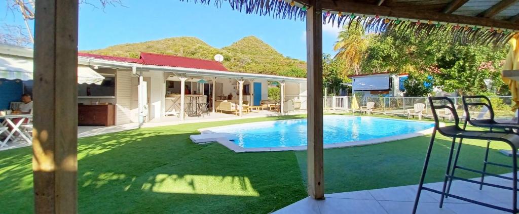 a backyard with a swimming pool and a house at La Rose du Bresil Marie-Galante in Capesterre