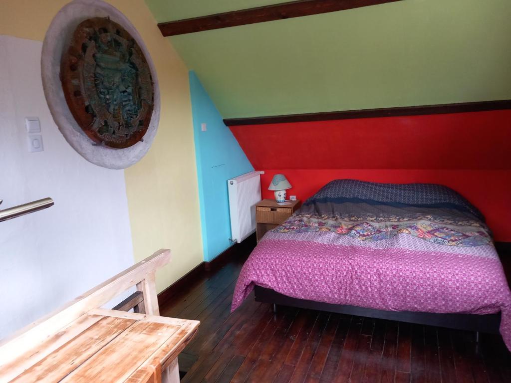 a bedroom with a bed with a red head board at maison d'artiste accès jardin in Maubeuge