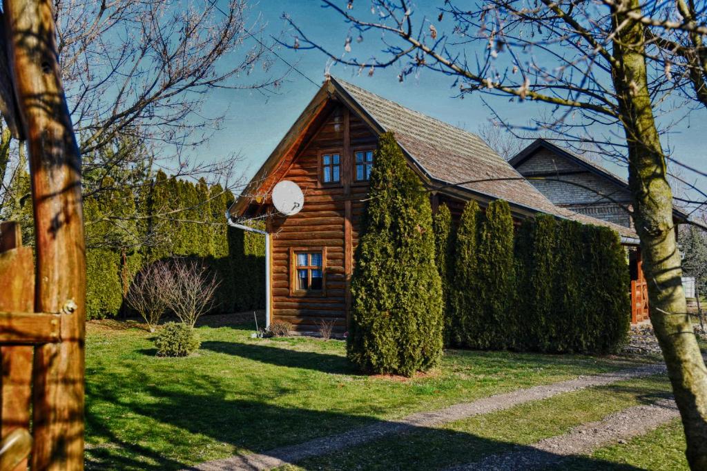 a small wooden house with a clock on it at Guesthouse Peto in Novi Kneževac