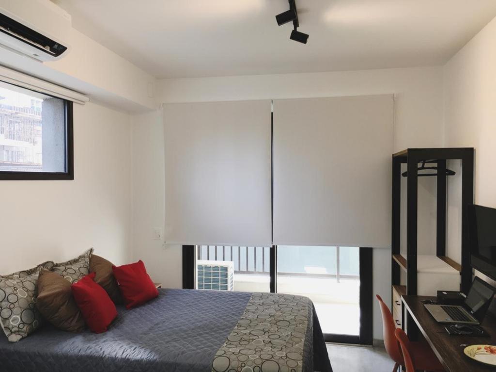 1 dormitorio con cama y ventana grande en Smart Studio Mobiliado na Vila Mariana, en São Paulo