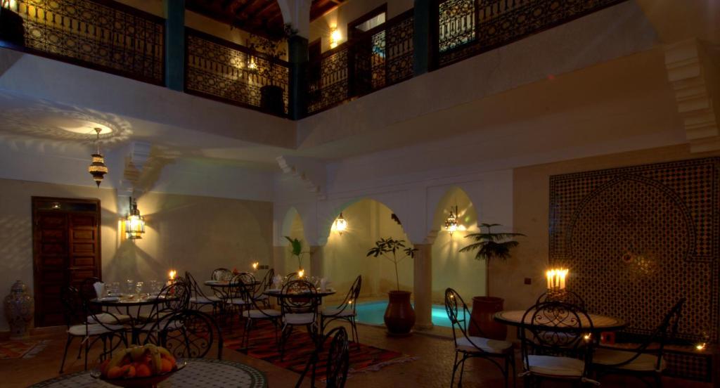 a room with tables and chairs in a room with lights at Riad Imilchil in Marrakesh
