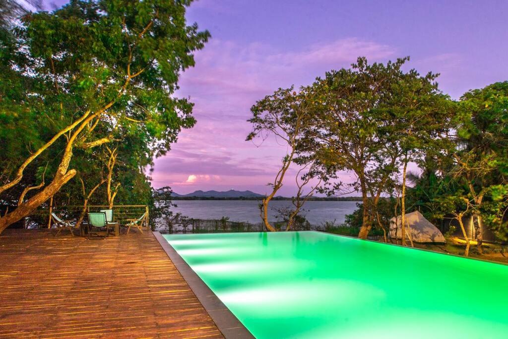 a pool on a deck with a view of the water at Yaal by Aryaana - Villa in Yala in Tissamaharama