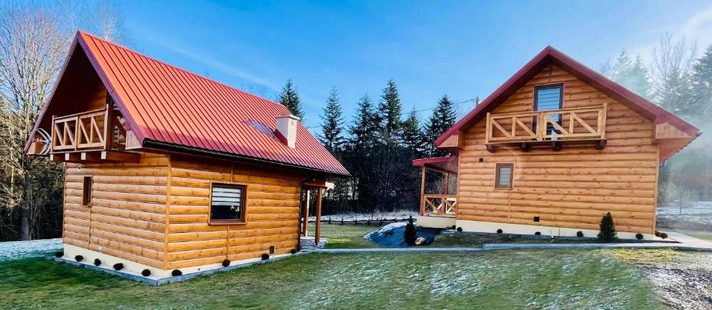 uma cabana de madeira com um telhado vermelho em Borówkowy Jar em Ropienka