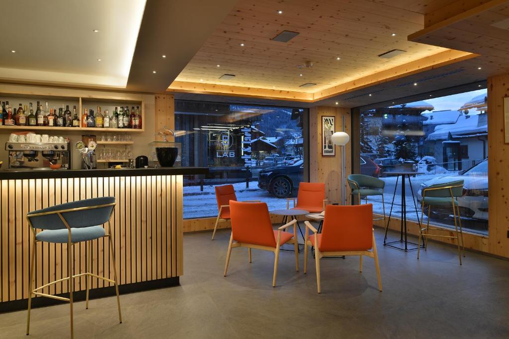 a restaurant with a table and chairs and a bar at Hotel St. Michael in Livigno