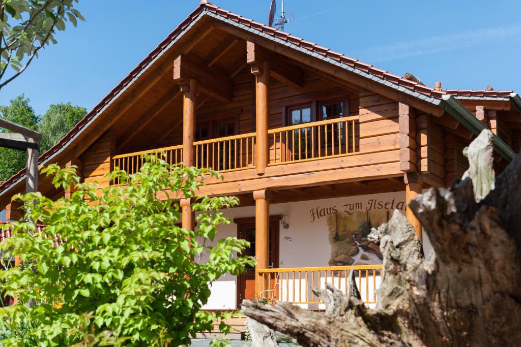 a large log cabin with a porch and balcony at Chalet zum Salamander in Ilsenburg