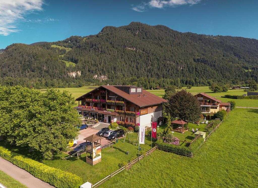 una vista aérea de una casa con una montaña en SALZANO Hotel - Spa - Restaurant, en Interlaken