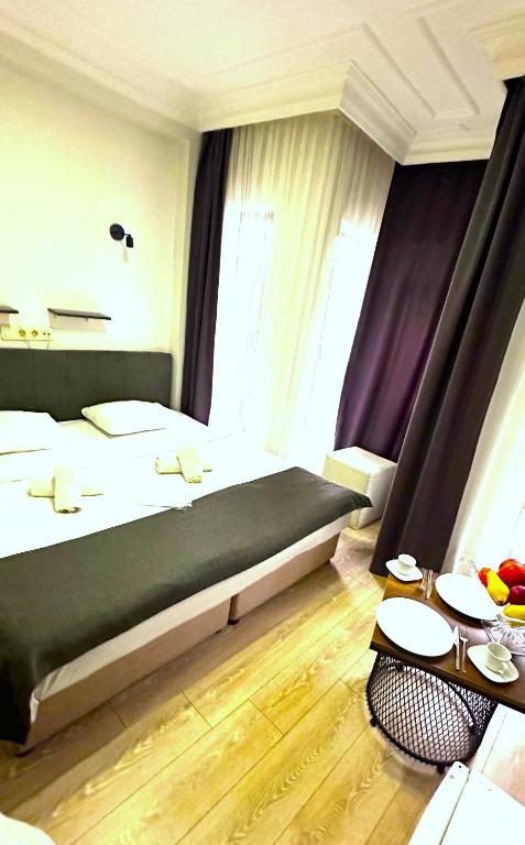 una habitación de hotel con una cama grande y una mesa en Istanbul Altun Life Hotel, en Estambul