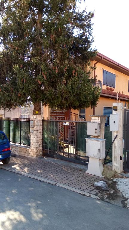 a building with a fence and a tree next to a street at Villa Giulia in Ateleta