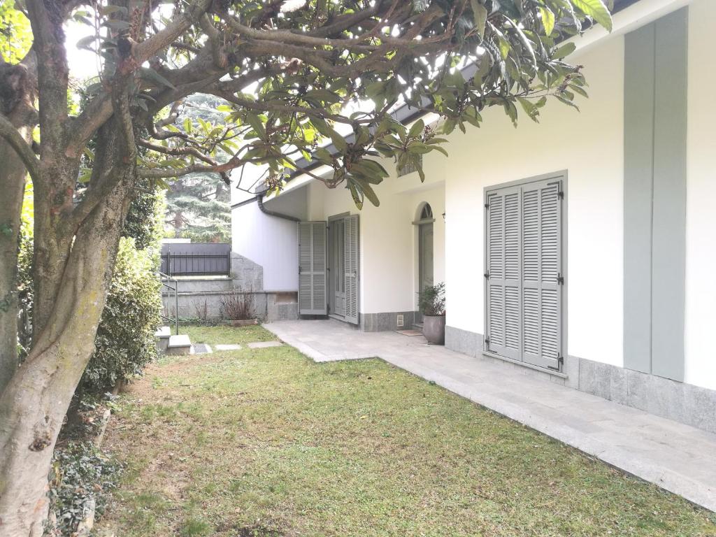 uma casa branca com uma árvore no quintal em Villa in Precollina em Turim