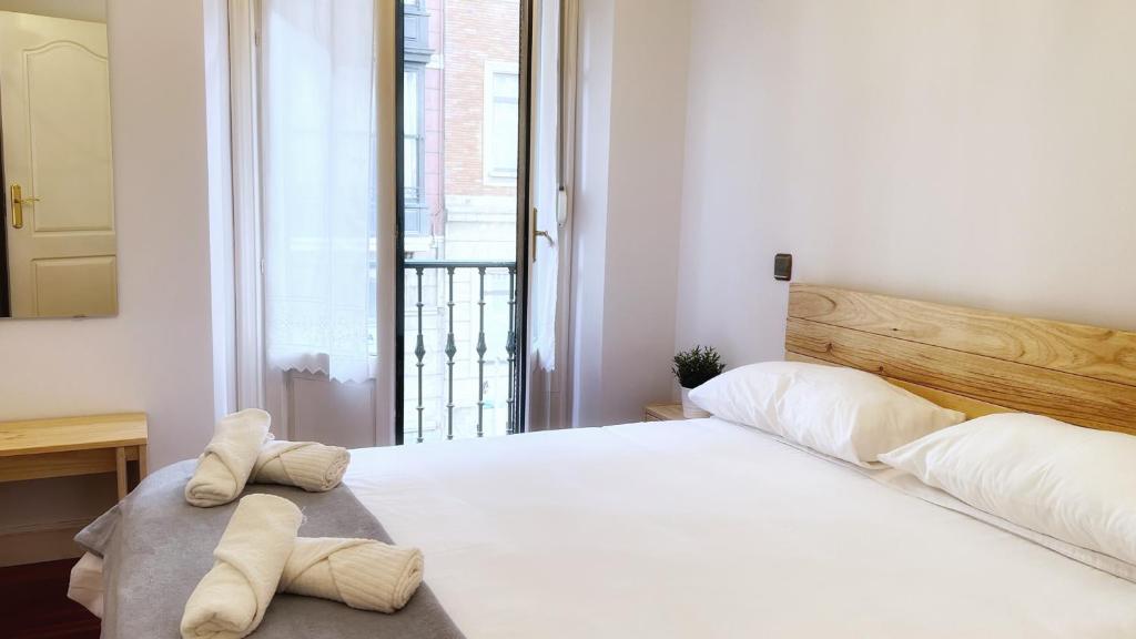 1 dormitorio con 1 cama blanca grande y toallas. en Amplio y acogedor cerca del Guggenheim, en Bilbao