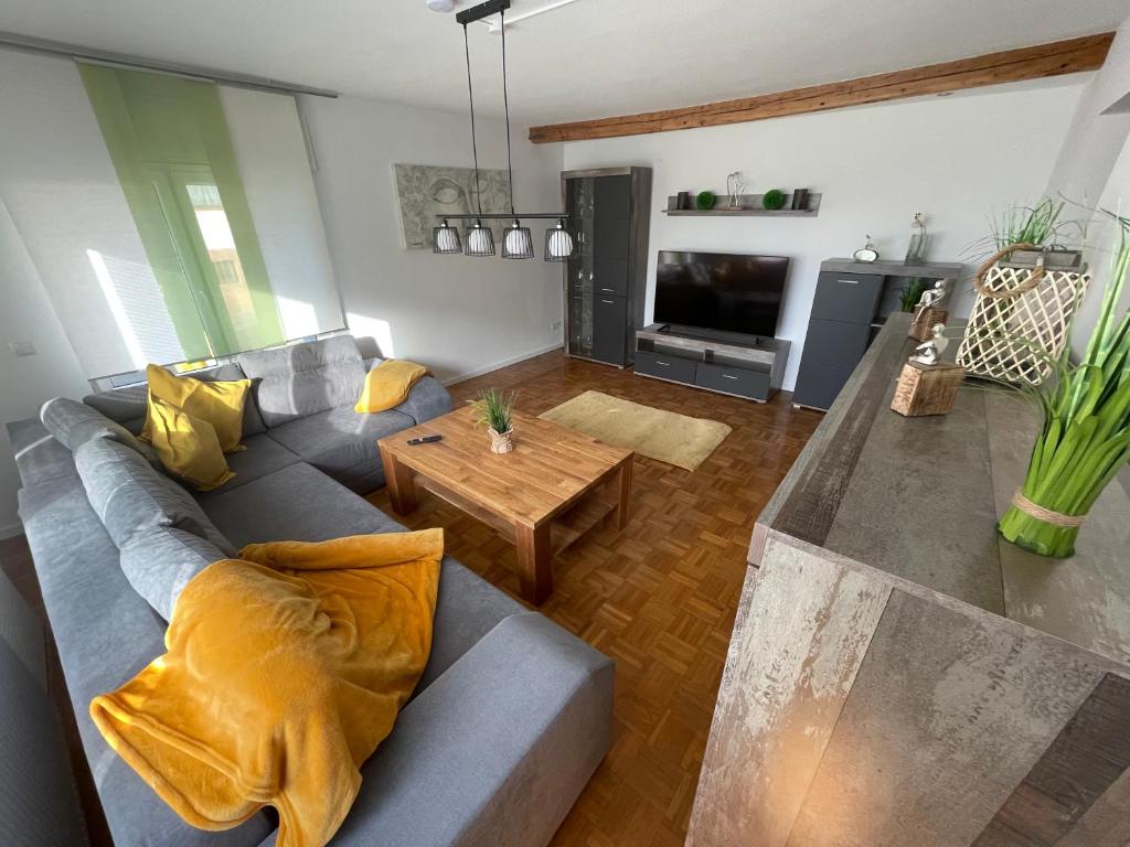 ein Wohnzimmer mit einem Sofa und einem Tisch in der Unterkunft Ferienhaus Rheinnähe in Lykershausen