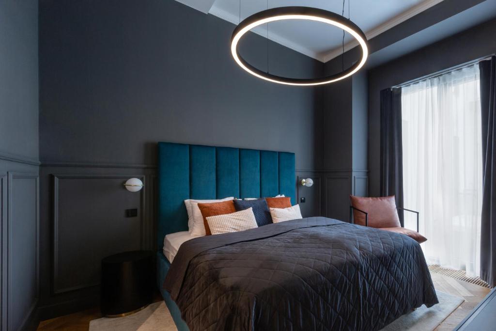 a bedroom with a large bed with a blue headboard at TurnKey I Premium Apartment in Prague