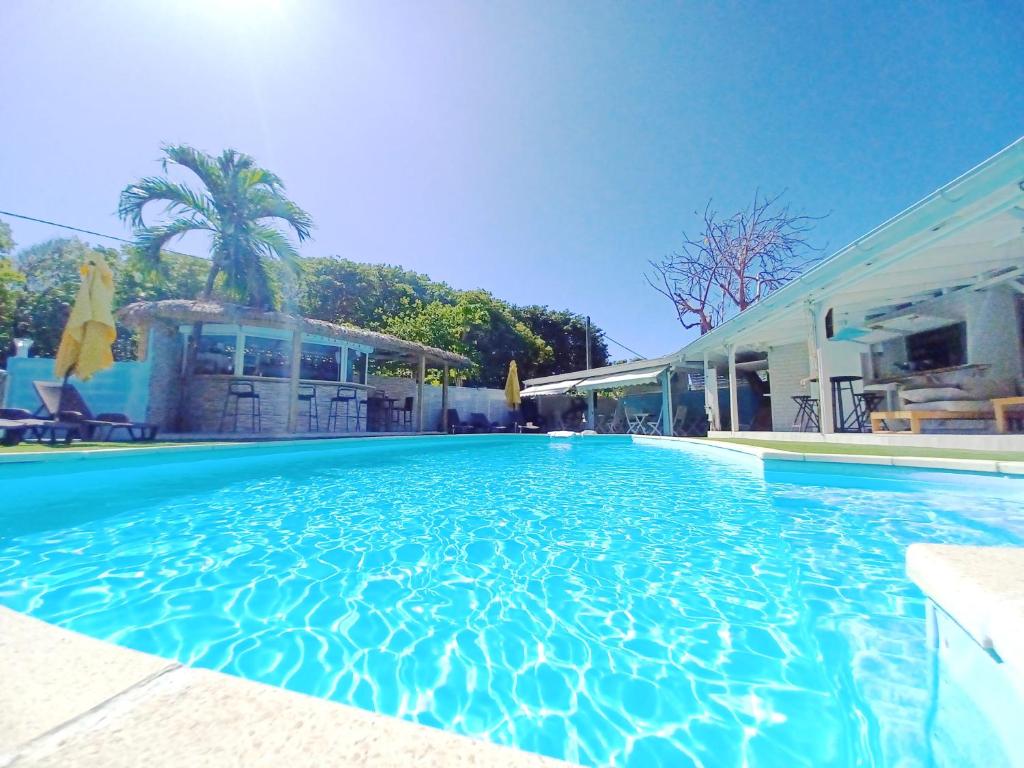 a large swimming pool next to a house at La Rose du Bresil Marie-Galante in Capesterre