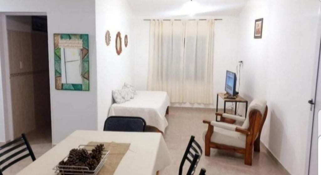 Habitación con sala de estar con mesa y sofá. en Departamento Aquí & Ahora con aire frio calor en Villa Carlos Paz