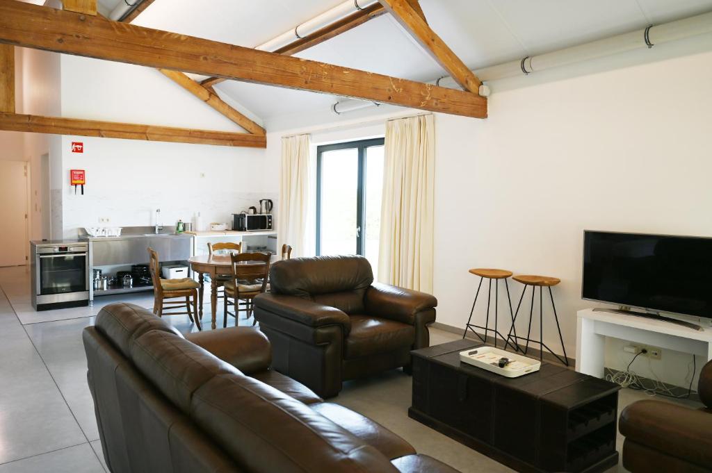 sala de estar con sofá, sillas y mesa en Landlord, en Holsbeek