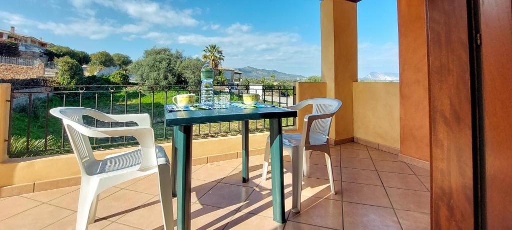 a balcony with a table and two white chairs at Appartamento Residenziale Bilocale Citai San Teodoro in San Teodoro