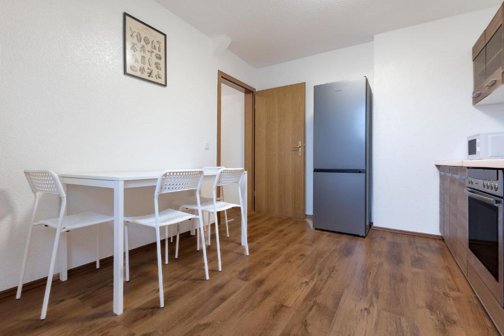 a kitchen with a table and chairs and a refrigerator at Duisburg - 2 Schlafzimmer Monteurwohnung - Vollausgestattete Küche - WIFI in Duisburg