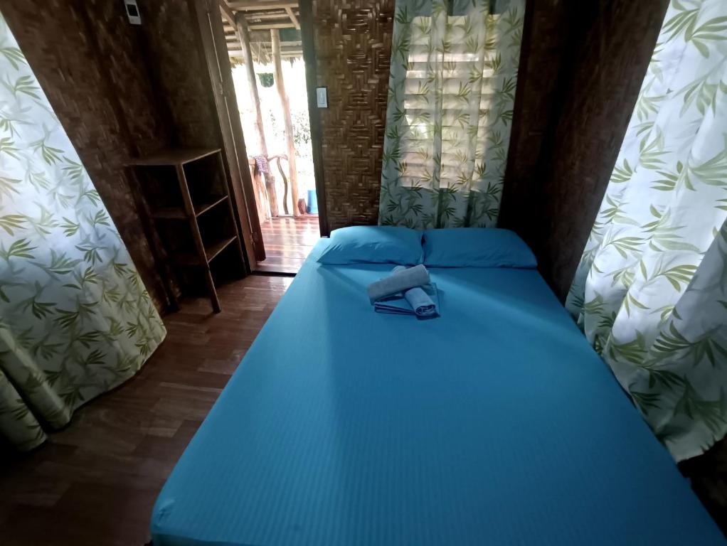 - un lit bleu avec une cravate au-dessus dans l'établissement Aventura Bed and Breakfast, à San Juan